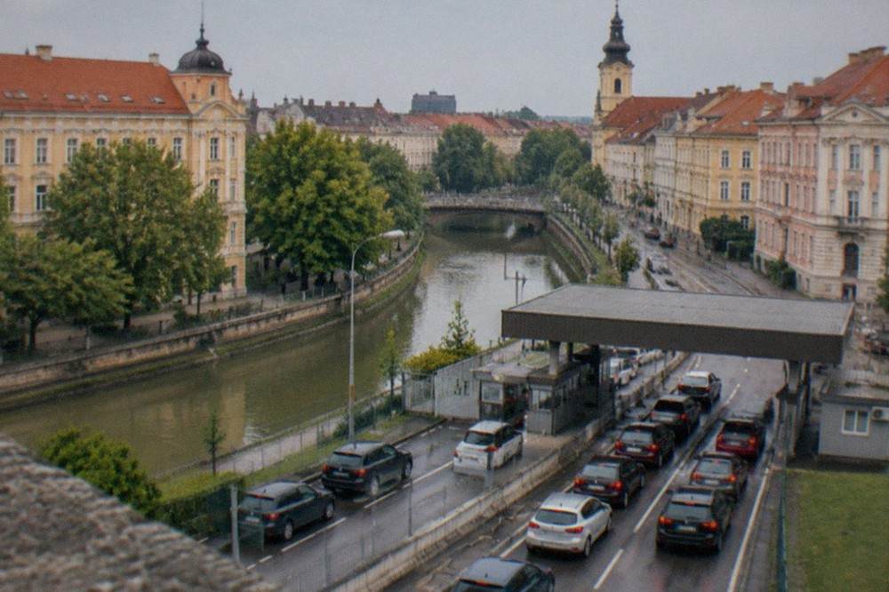Cars queuing at a small road border checkpoint between two countries
