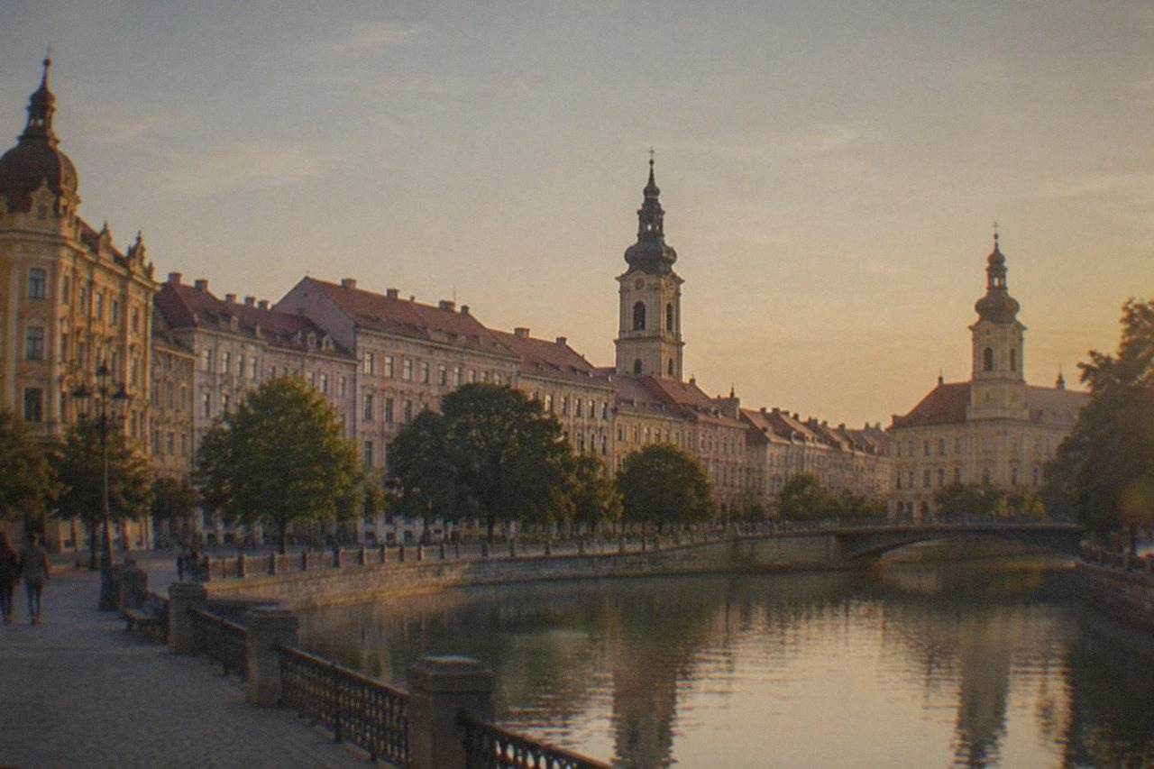 Panoramic view of colorful historic city squares and church spires in a Romanian city at golden hour