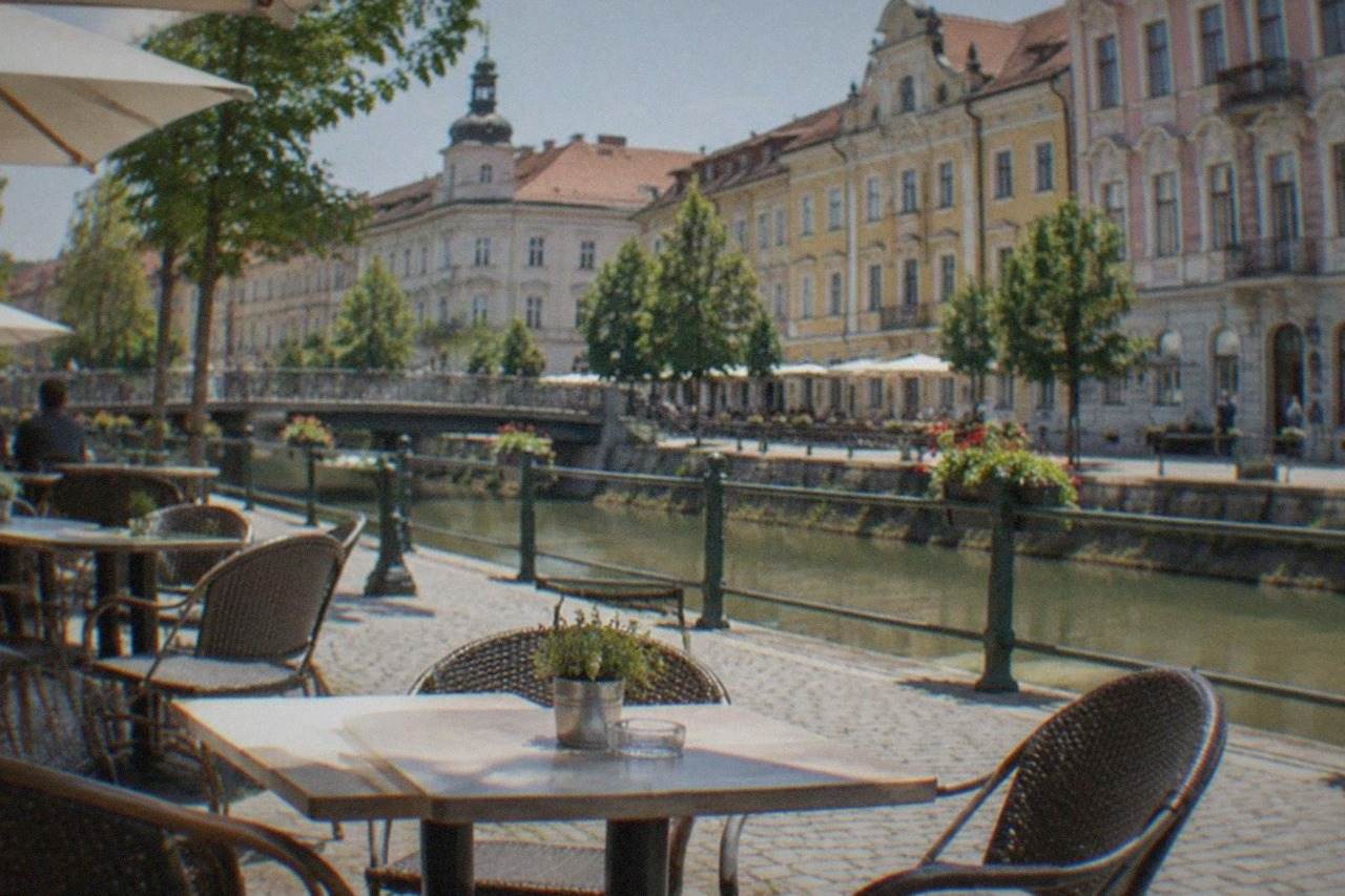 Outdoor cafe tables on a pedestrian square in Timisoara with colorful baroque buildings behind them