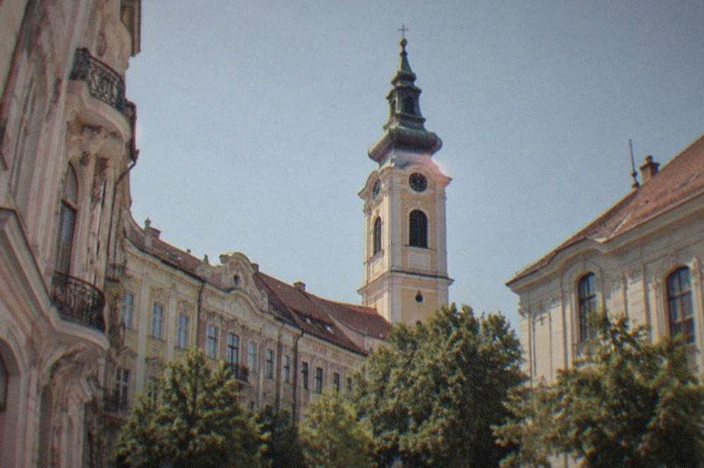 A church tower rising above the rooftops of Timisoara's old town