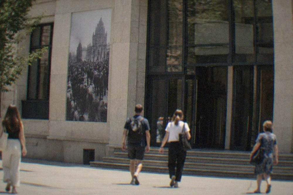 People walking past the Revolution Memorial museum building in central Timisoara