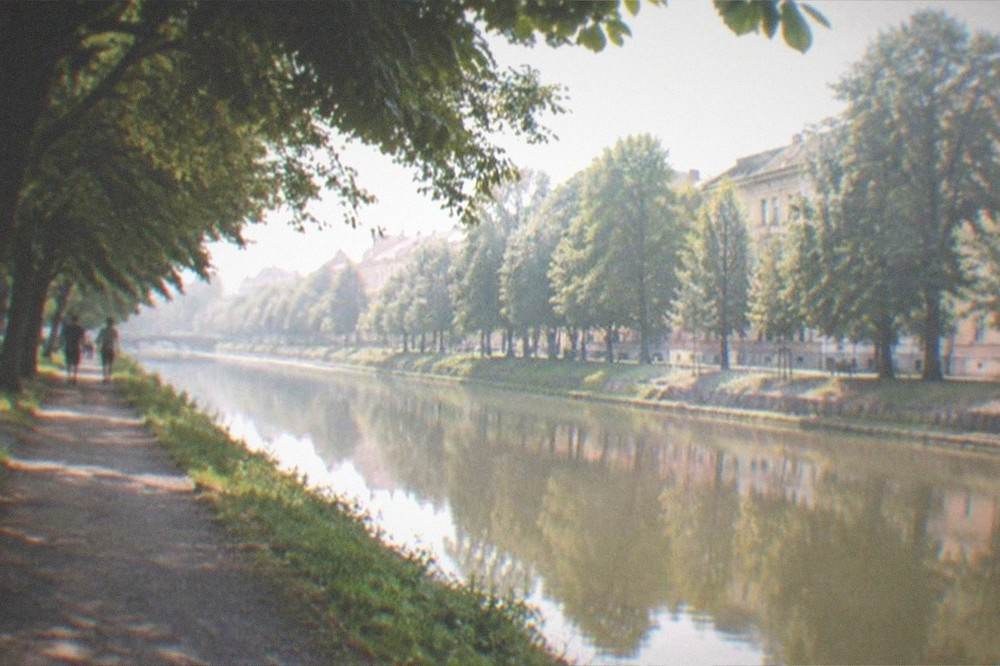 The Bega canal waterfront promenade at the northern edge of Elisabetin with trees reflected in the water
