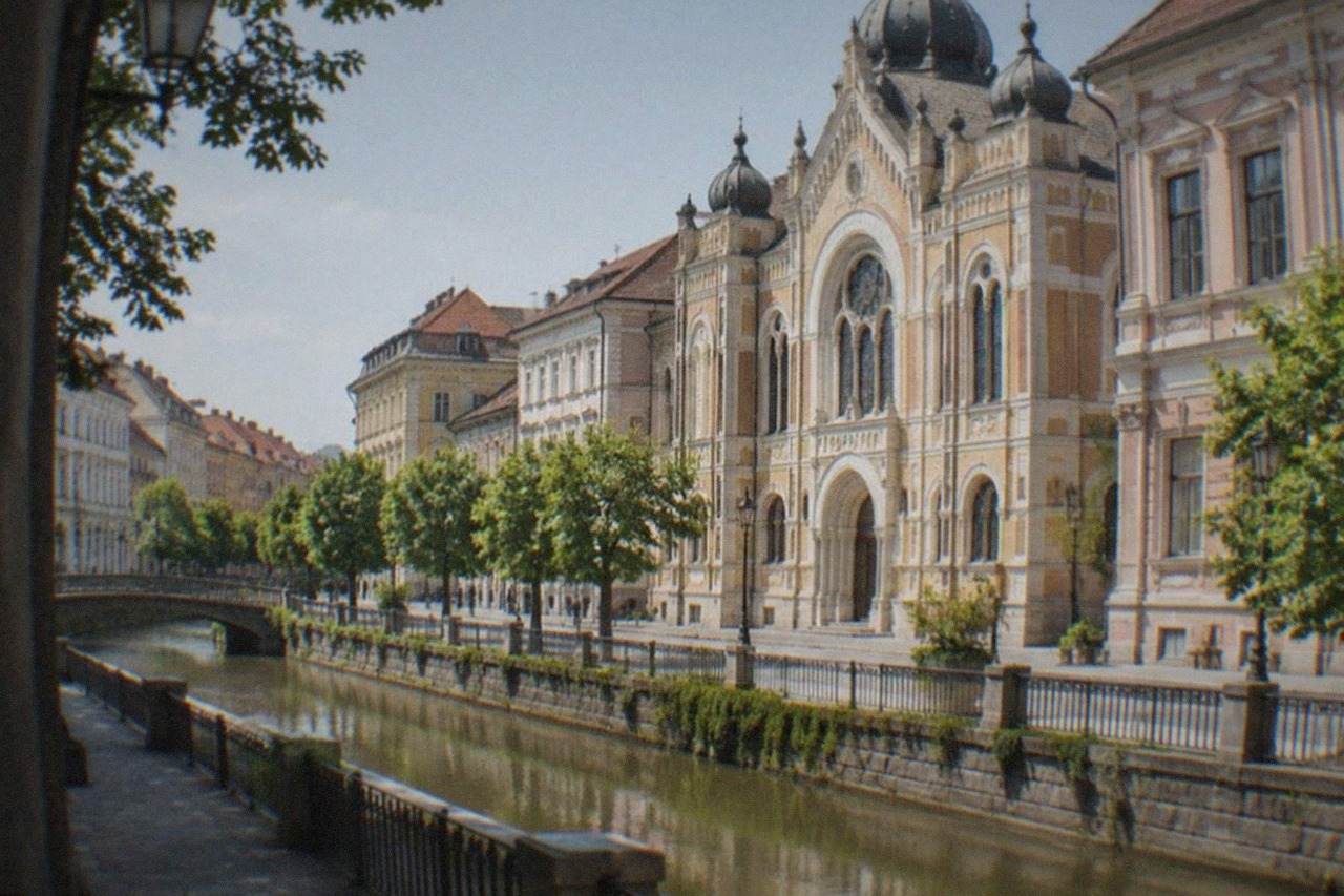 Ornate synagogue facade with arched windows on a quiet street in Timisoara