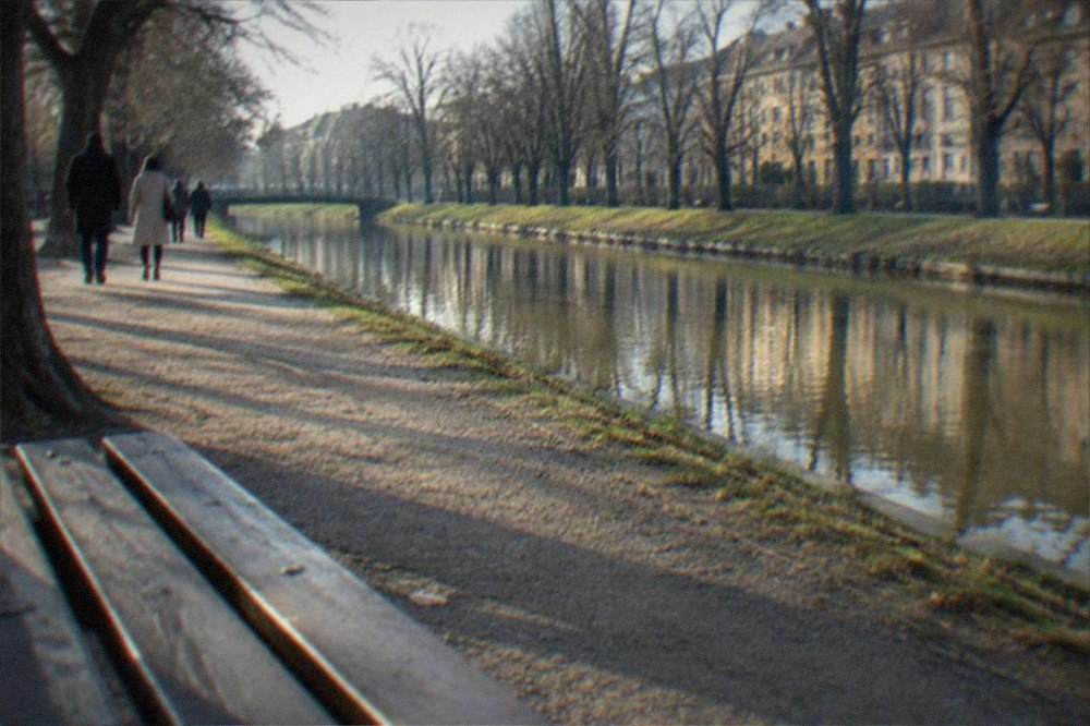 A wide view of the Bega canal promenade with trees and walkers in Timisoara