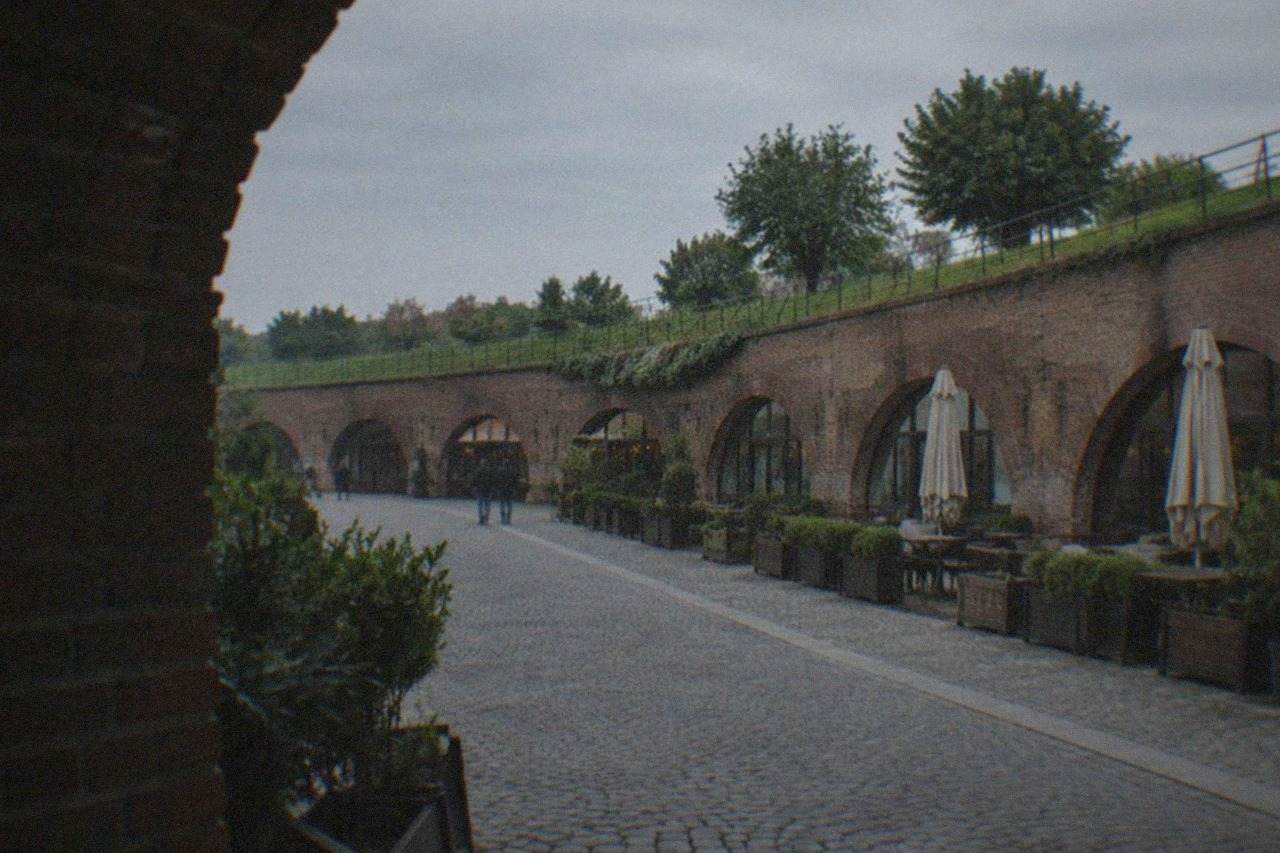 The curved stone walls of the Theresia Bastion in Timisoara with walkways and greenery along the top
