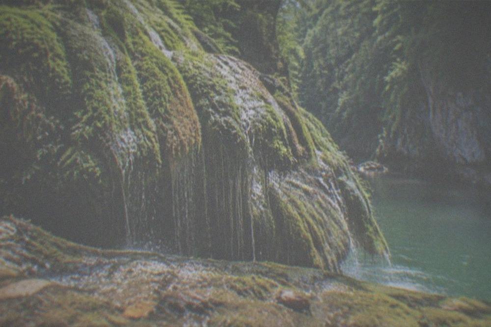 Turquoise river pools between limestone cliffs in a forested gorge
