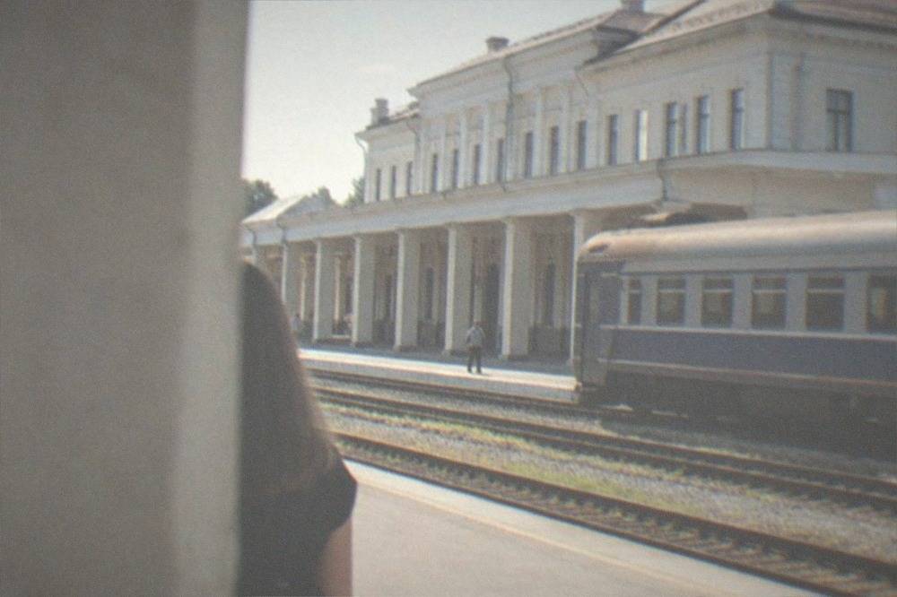 A train waiting at a Romanian railway station platform in morning light