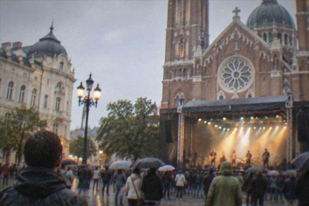 An evening festival stage set against a cathedral facade on a city square