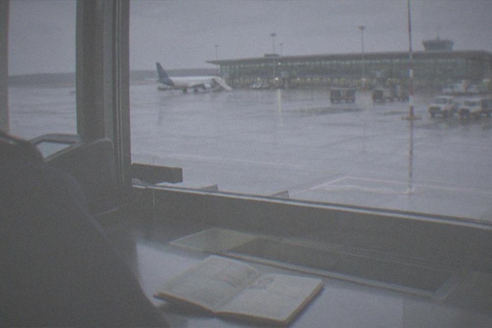 A border control booth at an airport with a passport open on the counter