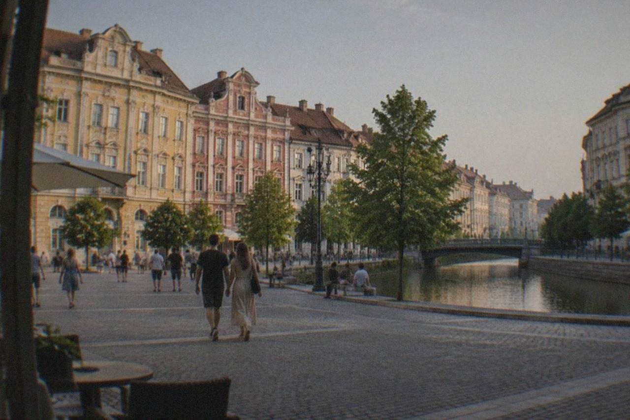 People strolling across a sunny square in central Timisoara with colorful baroque buildings