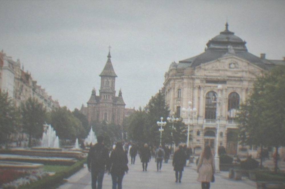 Visitors walking across Piata Victoriei toward the Opera building in Timisoara