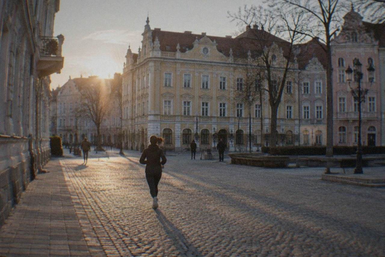 Pastel-colored baroque buildings around a square in Timisoara's old town at golden hour