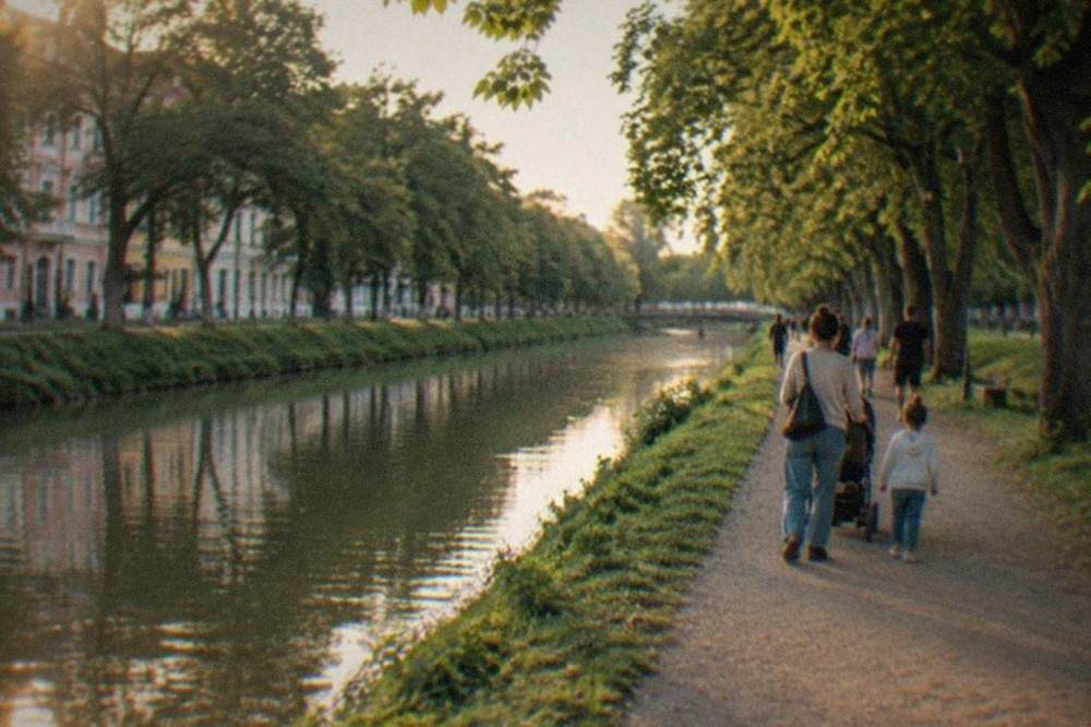 Families walking along the tree-lined Bega canal promenade in central Timisoara