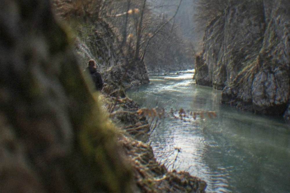 A turquoise stream winding through the forested Nera Gorge in the Banat mountains