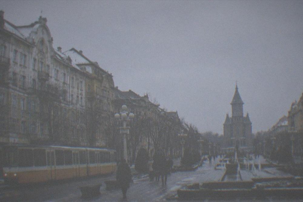 Tram passing decorated buildings in a European city in early winter