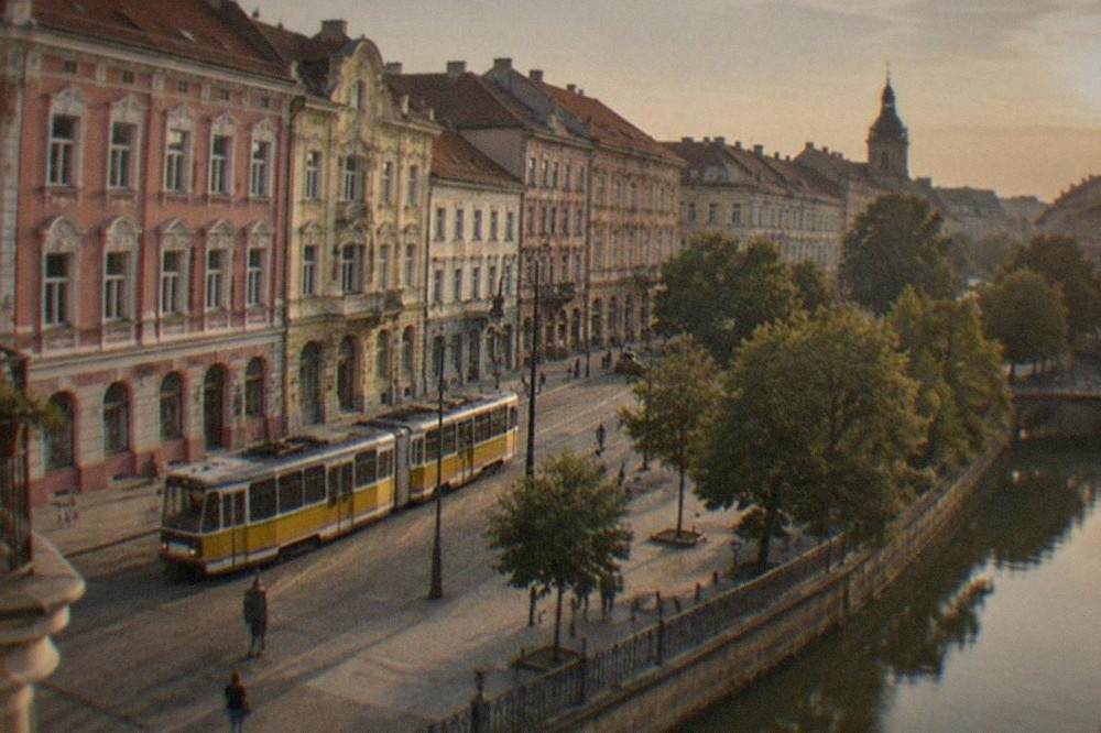 A tram passing colorful restored buildings on a street in central Timisoara