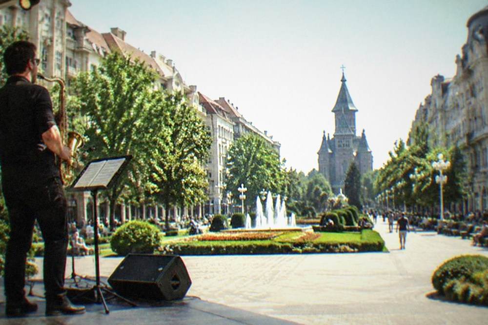 Saxophone player performing on a small concert hall stage under warm lights