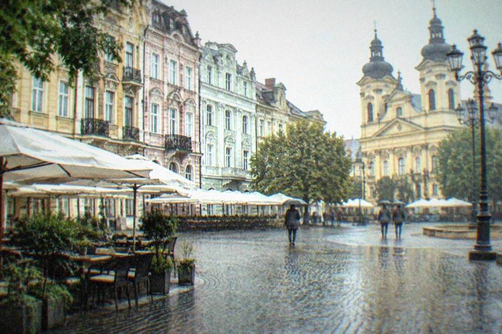 Restaurant terraces with parasols lining a baroque square in the old town
