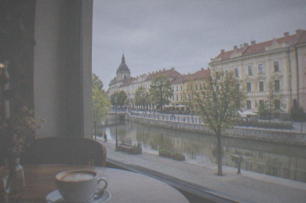 A cozy corner cafe interior in Timisoara with a coffee cup on a wooden table and soft window light