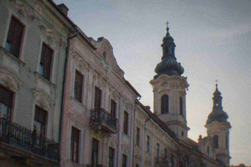 Two cathedral towers rising over the rooftops of Timisoara's main baroque square
