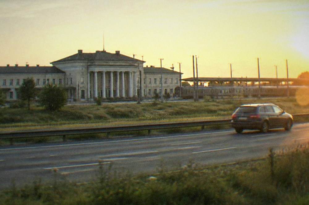 A car driving on a multi-lane motorway across open plains