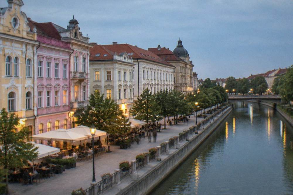 Pastel-painted historic buildings and cafe tables on a pedestrian street in Timisoara