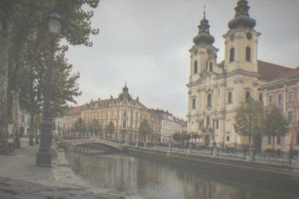 A baroque square with ornate church towers and pastel buildings in daylight
