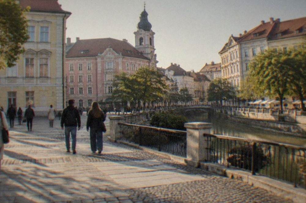 Pedestrians crossing a restored square lined with pastel facades