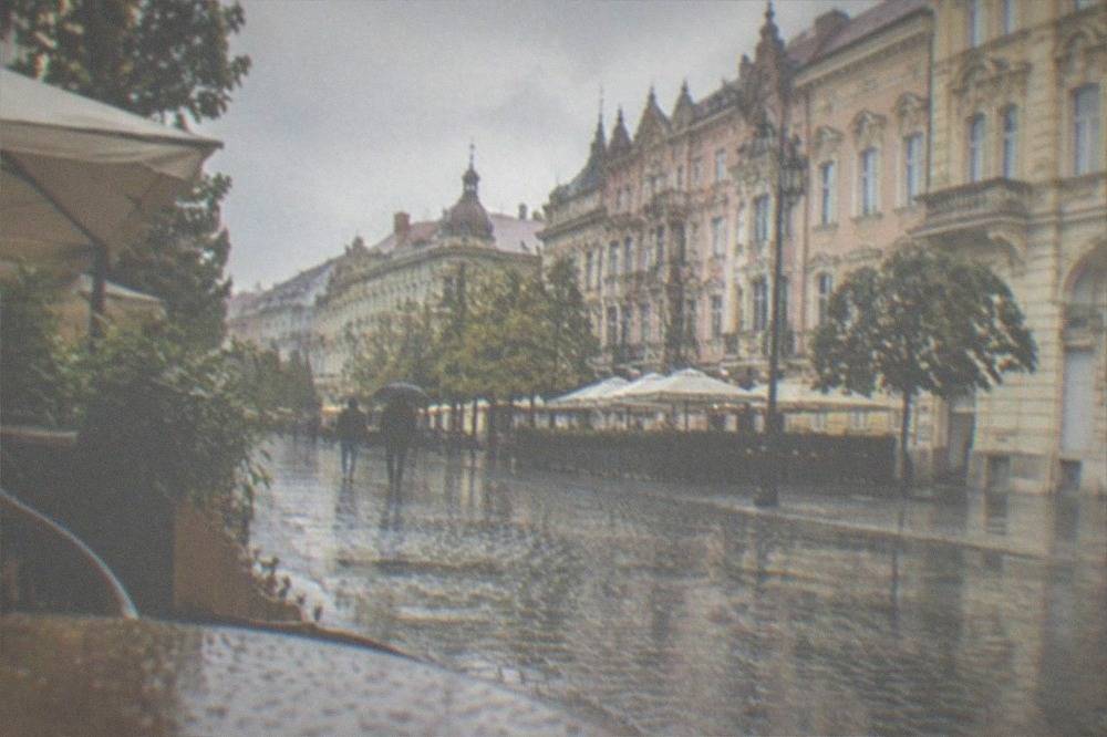 Rain-washed cobblestones and cafe terraces in a Timisoara old town street