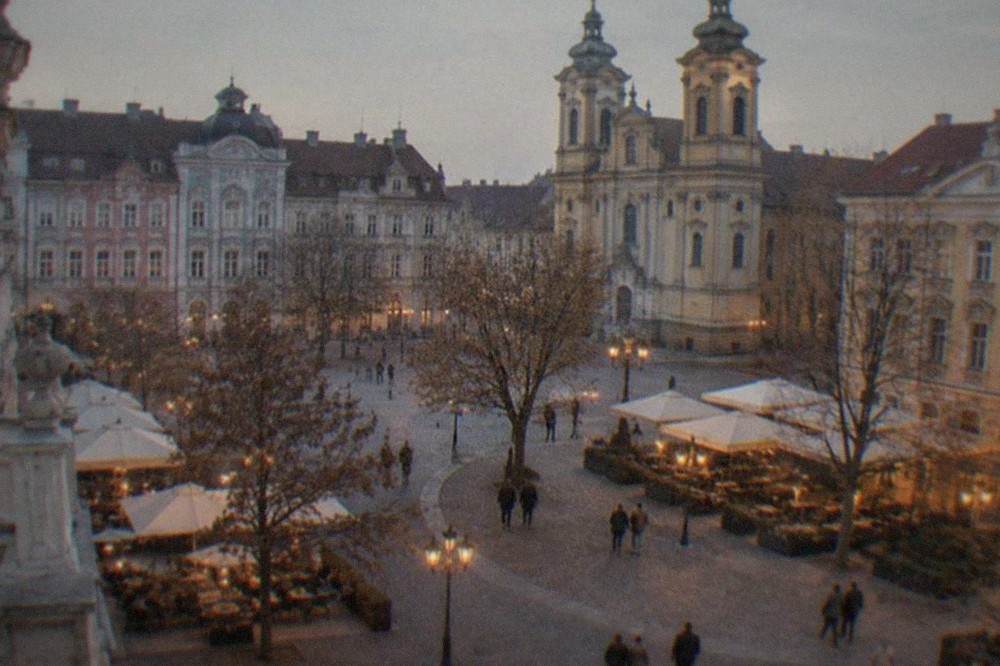 Evening lights and outdoor cafe tables in a baroque square