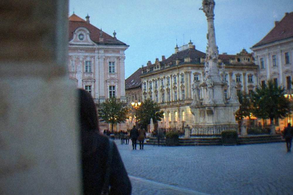 Pastel painted baroque buildings and a plague column in an old town square