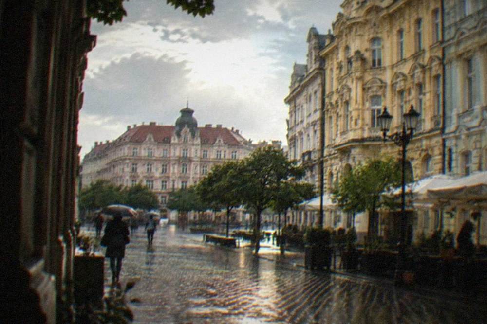 Rain-wet cobbled street with reflections and umbrella in a European old town