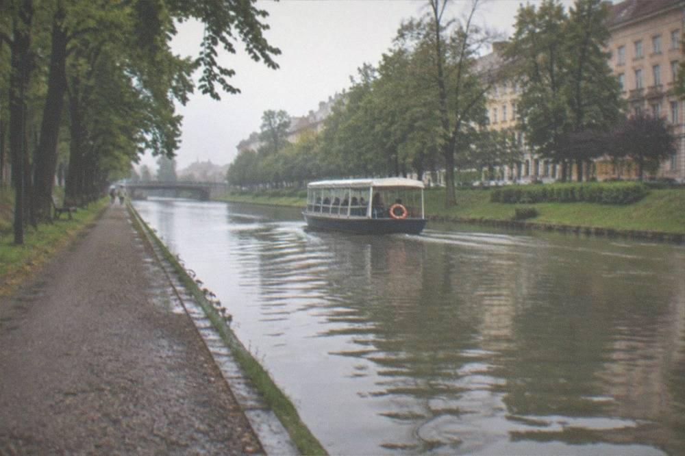 A small passenger boat moving along the Bega canal in Timisoara
